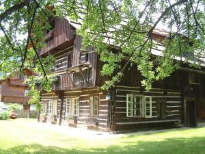 una gran casa de madera con árboles delante de ella en Ferienhaus Zipfmatl Keusche, en Bad Kleinkirchheim