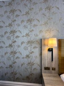 费利克斯托Hotel Coco的墙上的灯,墙上挂着植物壁纸