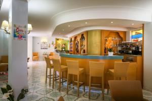 a bar in a restaurant with chairs and a counter at Hotel Rivamare in Ischia