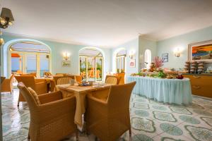 a restaurant with tables and chairs in a room at Hotel Rivamare in Ischia