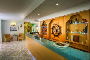 a kitchen with a counter with a large wheel on the wall at Hotel Rivamare in Ischia +37 photos