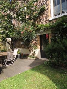 een patio met een bank naast een huis bij Chambre d'hôte le jardin de l'Esplanade Rennes Centre et gare in Rennes