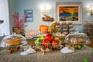 a table with two tiers of fruit and other food at Hotel Rivamare in Ischia