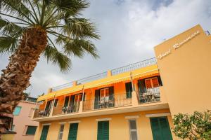 a building with a palm tree in front of it at Hotel Rivamare in Ischia