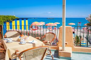a table and chairs with a view of the beach at Hotel Rivamare in Ischia