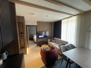 a living room with a couch and a tv at Woodside Apartment in Kopaonik