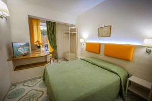 a hotel room with a bed and a desk at Hotel Rivamare in Ischia