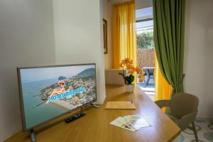 a flat screen tv sitting on top of a wooden table at Hotel Rivamare in Ischia