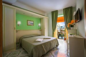 a bedroom with a bed with a green wall at Hotel Rivamare in Ischia