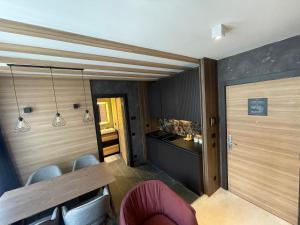a room with a table and chairs and a counter at Woodside Apartment in Kopaonik