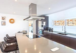 a kitchen with a counter and a sink and a stove at Villa BuenaVista Hills - Sea View - Infinity Pool - Parking - Grill in Málaga