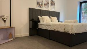 a bedroom with a bed with a black headboard at New Build 2 Bedroom Luxury Apartment, Jewellery Quarter Birmingham in Birmingham