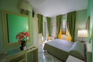 a bedroom with a bed and a green wall at Hotel Rivamare in Ischia