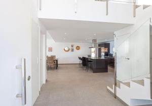 a living room and dining room with white walls at Villa BuenaVista Hills - Sea View - Infinity Pool - Parking - Grill in Málaga