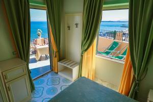 a room with a balcony with a view of the ocean at Hotel Rivamare in Ischia
