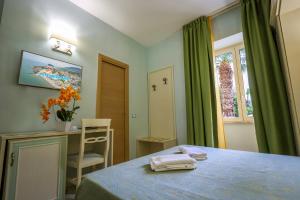 a bedroom with a bed and a desk and a window at Hotel Rivamare in Ischia