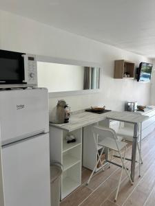 a kitchen with a table and a refrigerator at Studio thalie in Bormes-les-Mimosas