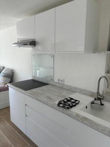 a white kitchen with a counter and a sink at Studio thalie in Bormes-les-Mimosas