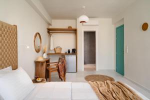 阿吉奥斯普罗科皮奥斯álas cycladic suites的一间有床、桌子和厨房的房间