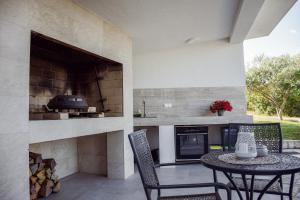 a patio with a table and chairs and an oven at Apartments Petra in Risika
