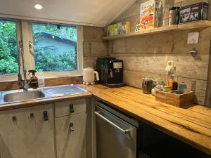 a kitchen with a sink and a wooden counter top at Dreamwoodz - een droomchalet op de Veluwe in Laag-Soeren +12 photos