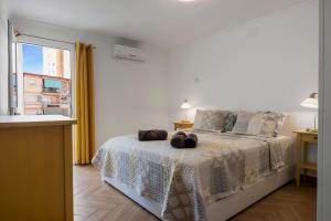 une chambre blanche avec un lit et une fenêtre dans l'établissement Sunny apartment in the Center, 5 min. from the Beach, à Fuengirola