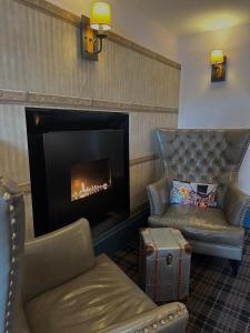 a living room with a chair and a fireplace at The Tobermory Hotel in Tobermory