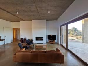 ein Wohnzimmer mit Sofa und Fernseher in der Unterkunft Casa de Mosqueirões in Santa Margarida da Serra