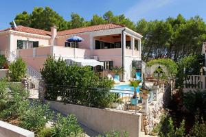 a house with a swimming pool in front of it at Villa Rosada in Vela Luka