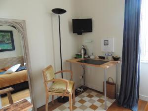 een kamer met een bureau, een stoel en een spiegel bij Chambre d'hôte le jardin de l'Esplanade Rennes Centre et gare in Rennes