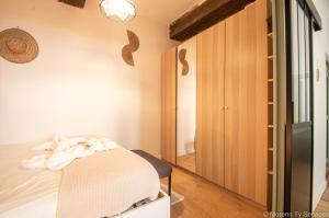 a room with a bed and a closet and a mirror at T2 de charme vieux Rennes - Ty ar Vasselot in Rennes