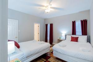 2 camas en una habitación con cortinas rojas en Hazel's Happy Hideaway- Midtown Mobile!, en Mobile