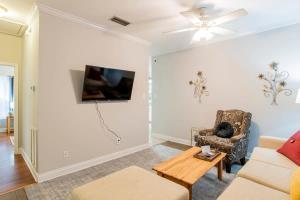 Una sala de estar con un sofá y un televisor en la pared. en Hazel's Happy Hideaway- Midtown Mobile!, en Mobile