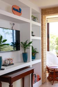 a living room with white shelves and a tv at Piale Palms Makenzie Beach Front Apartment, Larnaca in Larnaka
