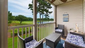 a porch with chairs and a table with a view at 55C Anchors Away II at True Blue condo by Peace Vacations in Pawleys Island