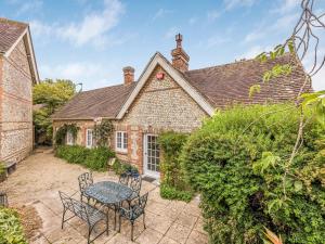 Una vista exterior de una casa de ladrillo con una mesa y sillas. en Charming Cottage With Amazing Views PassTheKeys, en Chichester