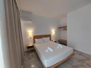 a bedroom with a bed with two towels on it at Blue Bay Hotel in Iraklitsa