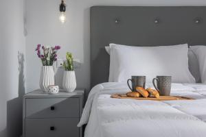 Káto ArkhánaiにあるIris Villa 2 - Archanes Creteのベッドにパンとカップ2杯のトレイ