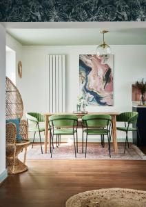 a dining room with a table and green chairs at Pass the Keys Coastal Boutique Luxury Home With Sea Views in Amlwch