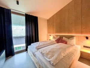 a bedroom with a large bed and a window at Apartment Hideaway Planneralm by Jufa Hotels-3 by Interhome in Donnersbach