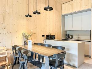 a kitchen and dining room with a wooden table and chairs at Apartment Hideaway Planneralm by Jufa Hotels-3 by Interhome in Donnersbach