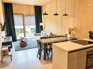 a kitchen and living room with a table and a couch at Apartment Hideaway Planneralm by Jufa Hotels-3 by Interhome in Donnersbach +26 photos