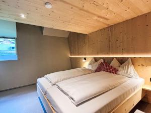 a bed in a room with a wooden ceiling at Apartment Hideaway Planneralm by Jufa Hotels-2 by Interhome in Donnersbach