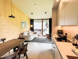 a kitchen and living room with a couch and a table at Apartment Hideaway Planneralm by Jufa Hotels-2 by Interhome in Donnersbach +16 photos