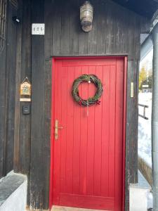 a red door with a wreath on it at Chata Violka Kvilda in Kvilda