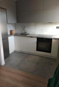 an empty kitchen with a sink and a stove at Apartament Kilińskiego in Ełk