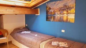 a bedroom with two beds and a painting on the wall at Il Borghetto Villa Pallante - Villa with Private Garden and Access to Swimming Pool in Cissano +15 photos