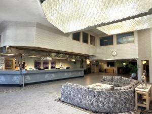 ポートランドにあるSojourn Suites Portland Airportのソファとバーのある広いロビー