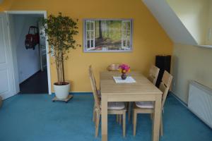 een eettafel met stoelen en een plant bij Brocken in Sicht in Goslar