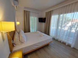a hotel room with a bed and a large window at Blue Bay Hotel in Iraklitsa